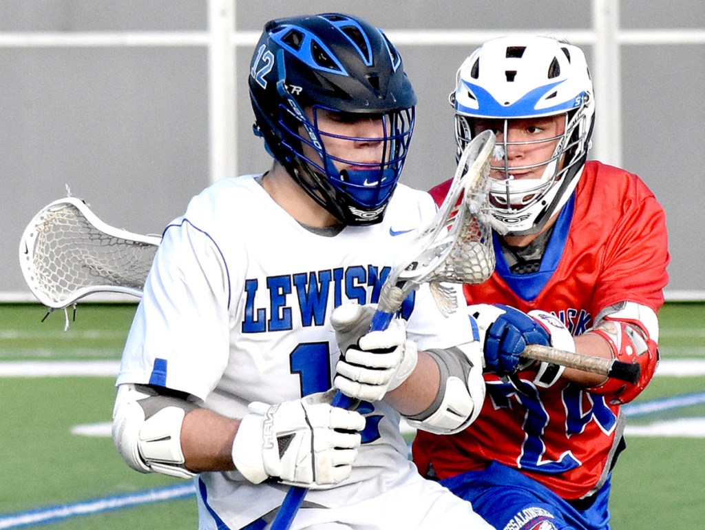 Lewiston high School's Garrett Poussard, left, braces for a hit from Messalonskee's Dan Gusmanou during their game on Garcelon Field at Bates College in Lewiston on Tuesday.