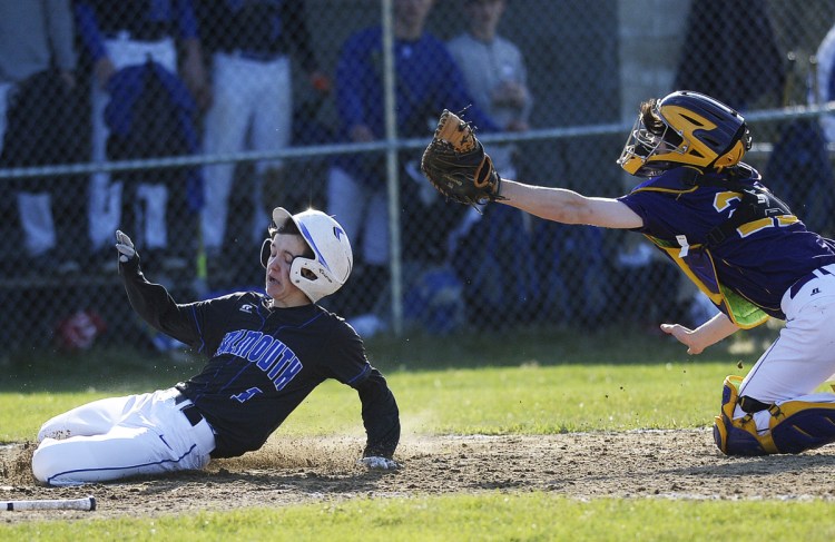 Falmouth's Connor Coffin slides under the tag of Cheverus catcher Andrew Young in Tuesday's game at Falmouth. The Yachtsmen went ahead for good in the third inning to win 3-1.