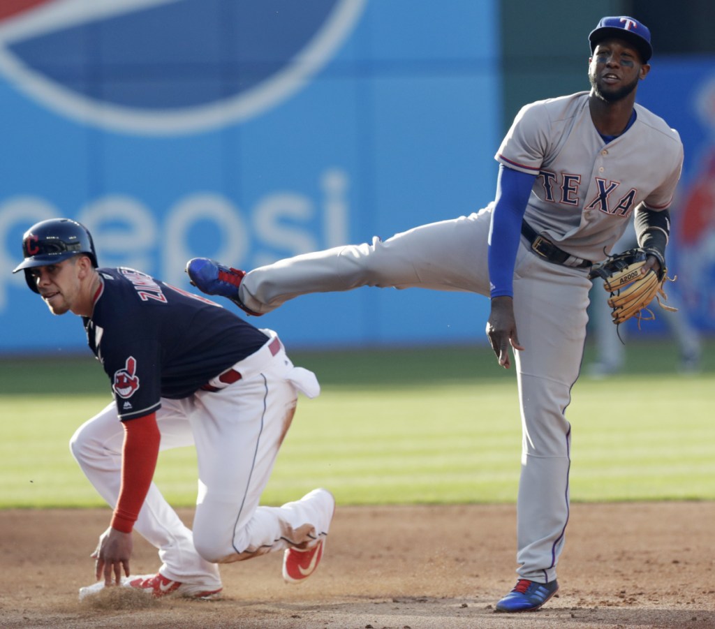 Jurickson Profar, right, of the Rangers looks toward first base after getting Cleveland's Bradley Zimmer out at second base in the third inning of Tuesday's game. Francisco Lindor was out at first base for the double play. Texas won in 12 innings, 8-6.