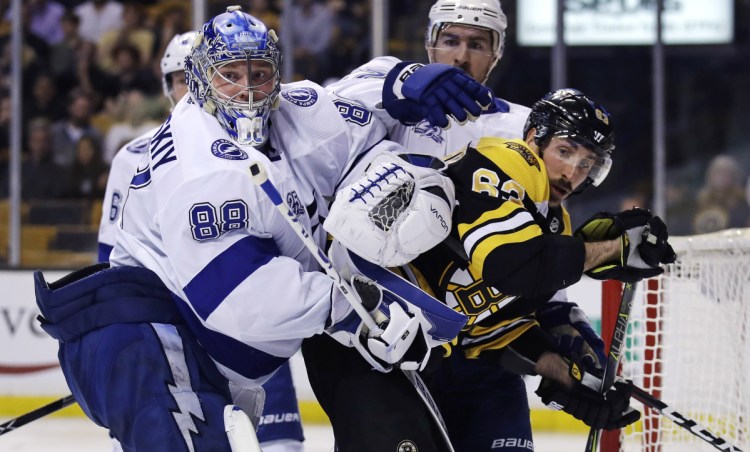 Tampa Bay Lightning goaltender Andrei Vasilevskiy tangles with Boston Bruins left wing Brad Marchand during the second period Wednesday night in Boston.