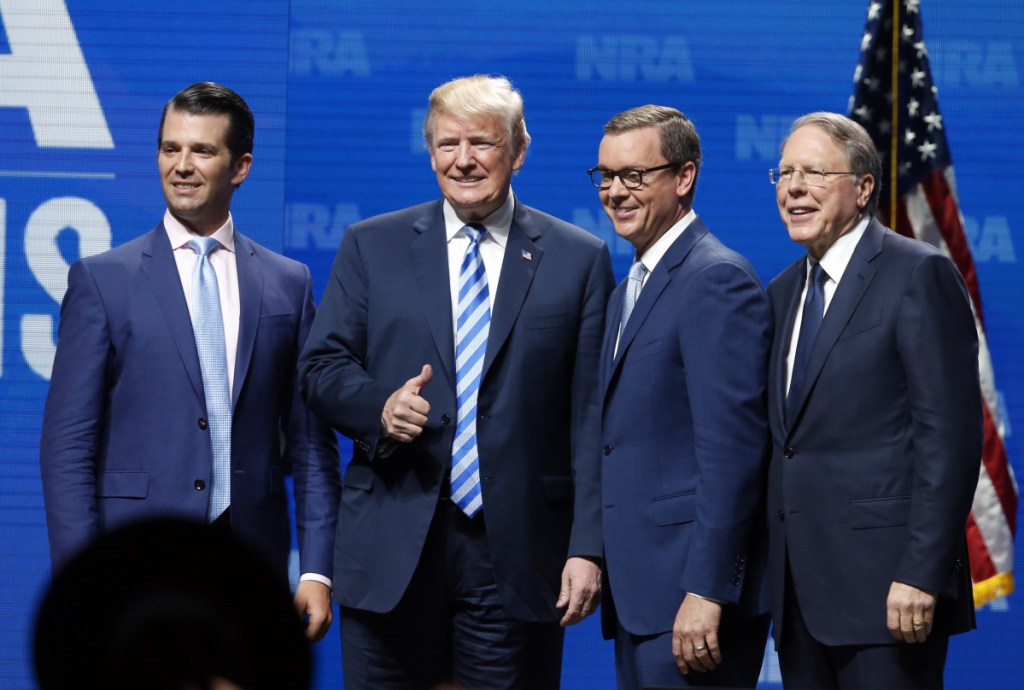 Donald Trump Jr., from left, President Trump, Chris Cox, executive director of the National Rifle Association-Institute for Legislative Action Leadership Forum and NRA executive vice president Wayne LaPierre, right, stand on stage at the NRA meeting in Dallas on Friday.