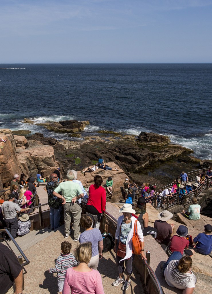 Tourists flock to Thunder Hole at Acadia National Park, where famous waves crash against the rocks. Public input is being sought on four different proposals to better manage park traffic and crowds.