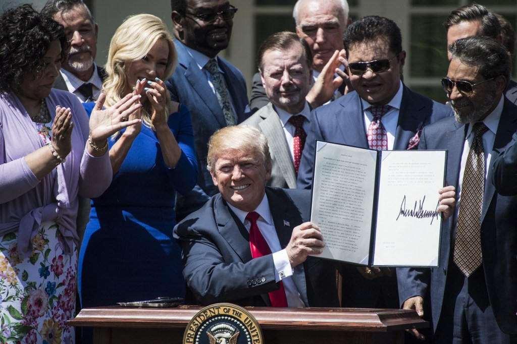 President Trump signs an Executive Order on the Establishment of a White House Faith and Opportunity Initiative during a National Day of Prayer event in the Rose Garden of the White House on Thursday. Trump said the order would expand government grants to and partnerships with faith-based groups. MUST CREDIT: Washington Post photo by Jabin Botsford