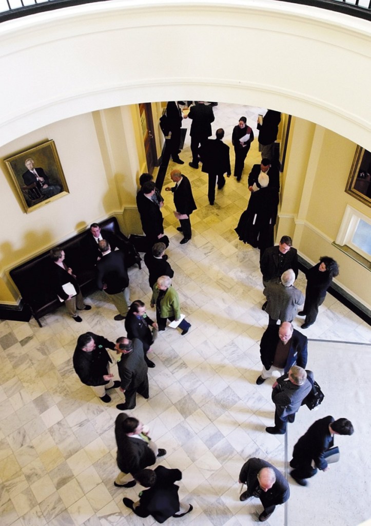 Lobbyists wait for lawmakers between the houses of the Legislature in Augusta. The private-interest lobby is more powerful because of legislators' term limits, a writer says.
