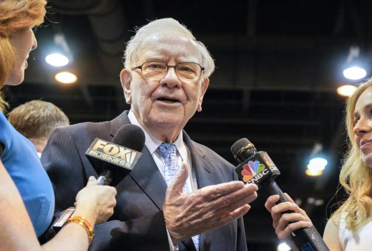 Warren Buffett, chairman and CEO of Berkshire Hathaway, speaks to reporters during a tour of the exhibit floor at the CenturyLink Center in Omaha, Neb., on Saturday.