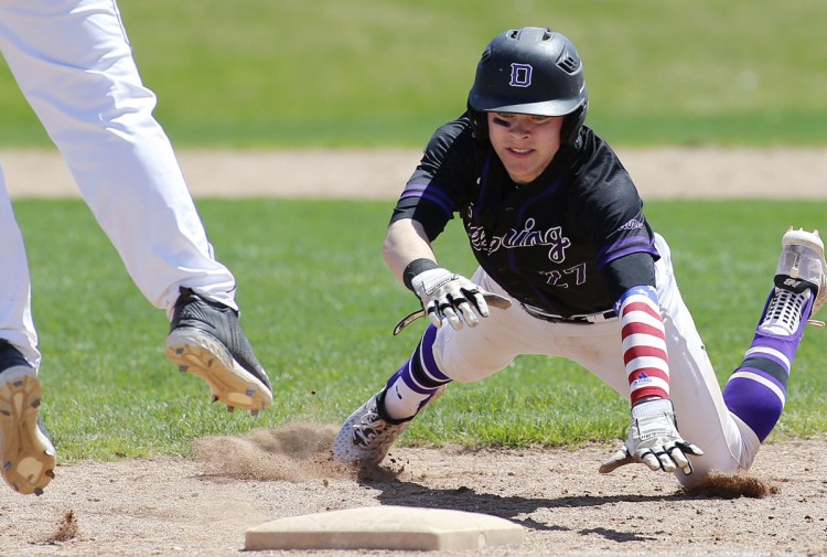 Jack Lynch of Deering dives safely back to first base as Westbrook's Jack Stone leaps for a pickoff attempt by pitcher Destin Delponte.