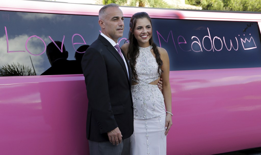 Andrew Pollack, father of Meadow Pollack, poses with his daughter's best friend, Carley Ogozaly, next to a limousine with messages to honor her written by friends before heading to the prom. Meadow Pollack was one of the four Florida high school seniors slain in a mass shooting.