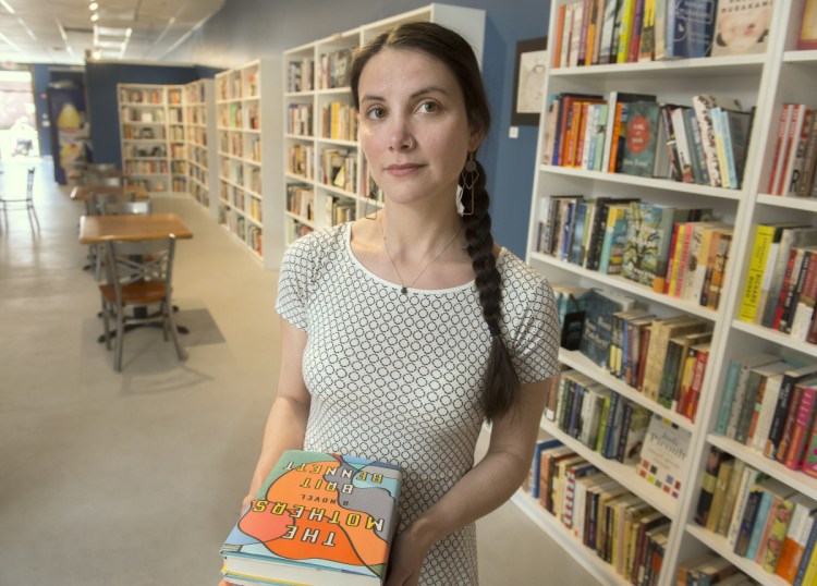 Allison Krzanowski, co-owner of Quill Books and Beverage in Westbrook, pulled books written by Junot Diaz from her shelves recently.