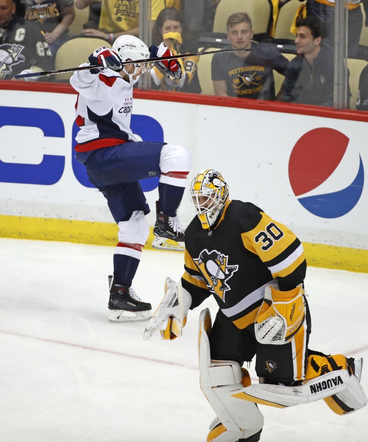 Evgeny Kuznetsov of the Washington Capitals celebrates Monday night as Pittsburgh Penguins goaltender Matt Murray skates off after allowing the winning goal.