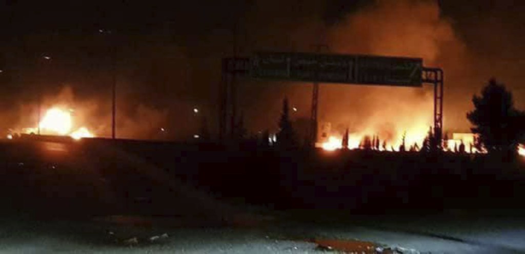 This photo released Wednesday by the Syrian official news agency SANA shows flames rising after an attack in an area known to have numerous Syrian army military bases, in Kisweh, south of Damascus, Syria.