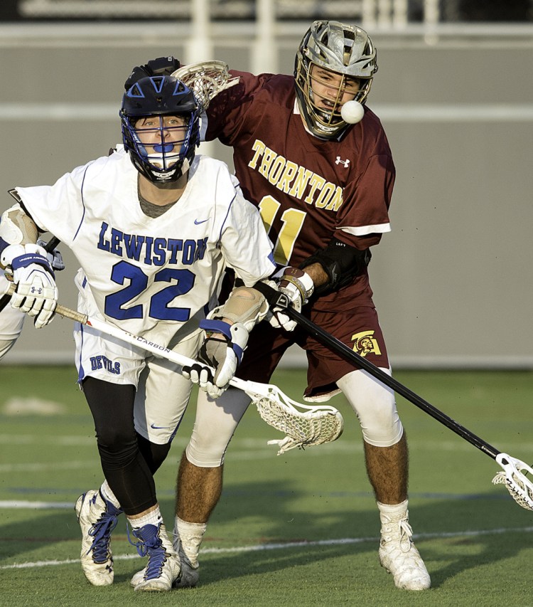 Brayden Charest, left, of Lewiston and Cameron Houde of Thornton Academy battle for the ball during Thornton's 15-9 lacrosse victory Thursday in Lewiston.