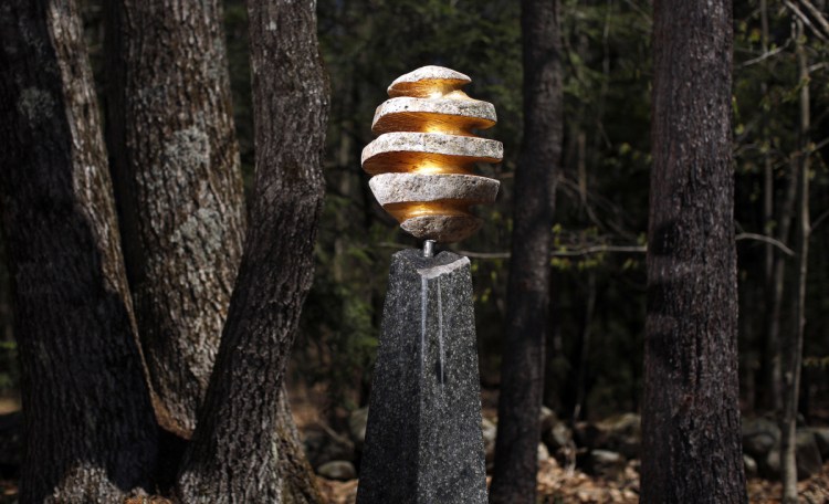 "Ascension II," a scultpted glacial bouler on a granite pedestal with gold leaf, is part of a sculpture show at June LaCombe's Hawk Ridge Farm in Pownal highlighting the works of Gary Haven Smith, who died last fall. Below, "Over and Under," a work in granite by Smith. LaCombe is featuring about a dozen other works by Smith in a wider exhibition on view through late June.