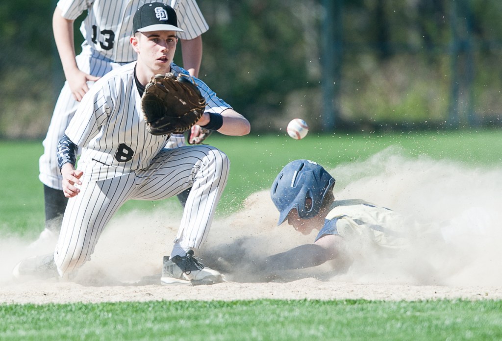 Traip Academy's Charlie Driscoll slides into second with a stolen base, ahead of the tag by Hunter Hughes of St. Dom's. Traip won, 11-2.