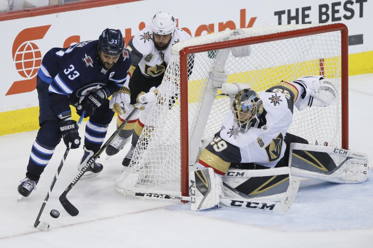 Winnipeg's Dustin Byfuglien attempts the wraparound on Vegas goaltender Marc-Andre Fleury during the third period of Game 1 of the NHL hockey playoffs Western Conference finals on Saturday night in Winnipeg. The Jets won, 4-2.