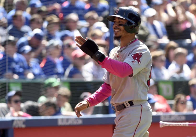 Mookie Betts celebrates after scoring in the fifth inning of the Red Sox' 5-3 win over the Blue Jays on Sunday in Toronto.