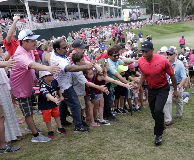 Fans greet Tiger Woods as he exits the 18 hole, during the final round of The Players Championship Sunday  in Ponte Vedra Beach, Fla.