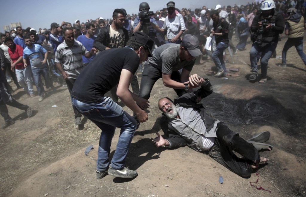 An elderly Palestinian man falls after being shot by Israeli troops during a protest at the Gaza Strip's border with Israel on Monday.