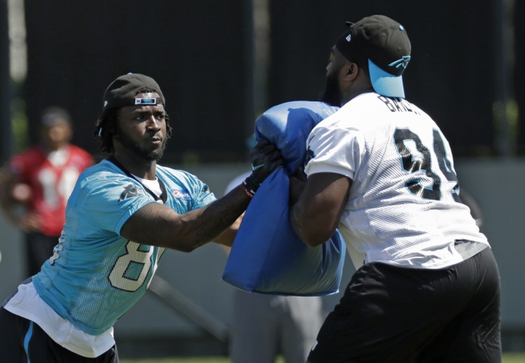 Carolina Panther Ian Thomas runs a drill against Sterling Bailey (94) during the team's rookie camp in Charlotte, N.C., on Friday. Sources say the team has been sold to hedge fund manager David Tepper.