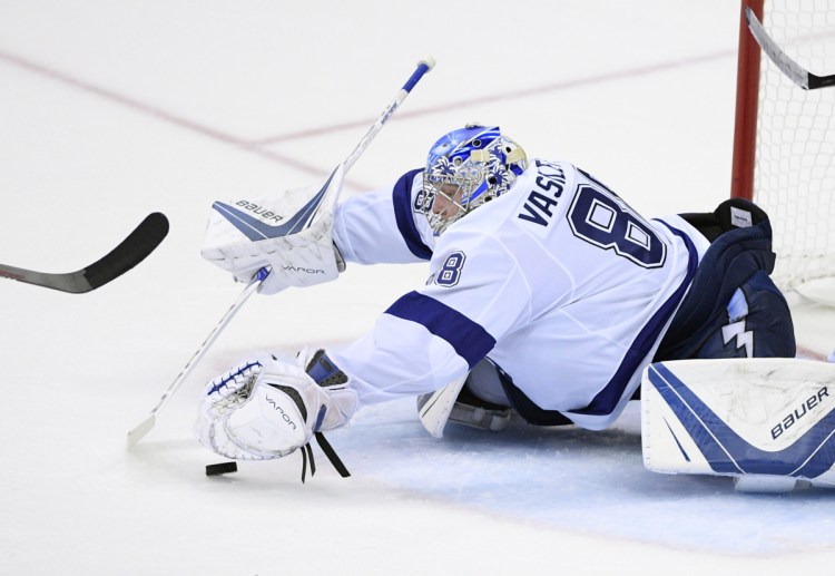 Tampa Bay goaltender Andrei Vasilevskiy reaches for the puck during the third period of Tuesday's game in Washington. Vasilevskiy made 36 saves as the Lightning beat the Capitals 4-2 and trail the Eastern Conference finals 2-1.