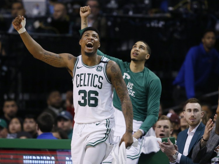Associated Press/Michael Dwyer 
 Boston's Marcus Smart, left, cheers from the bench during the fourth quarter of Game 1 of the Eastern Conference finals against the Cleveland Cavaliers on Sunday.