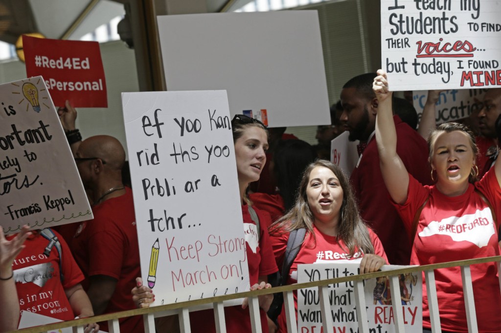 Educators gather outside the House and Senate chambers with signs during a teachers rally at the General Assembly in Raleigh, N.C., Wednesday. Teachers demanding better pay and more resources also filled the streets of North Carolina's capital city.