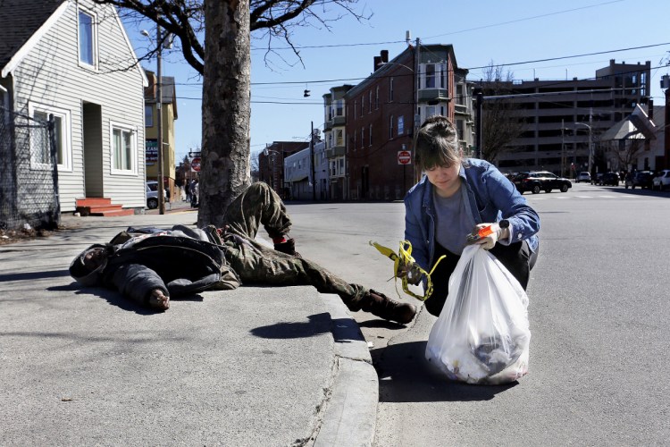 Letter writer Stephanie Scherer, shown picking up litter near an intoxicated man in Bayside, says if other parts of the city had open drug dealing and related violence it would be dealt with immediately.