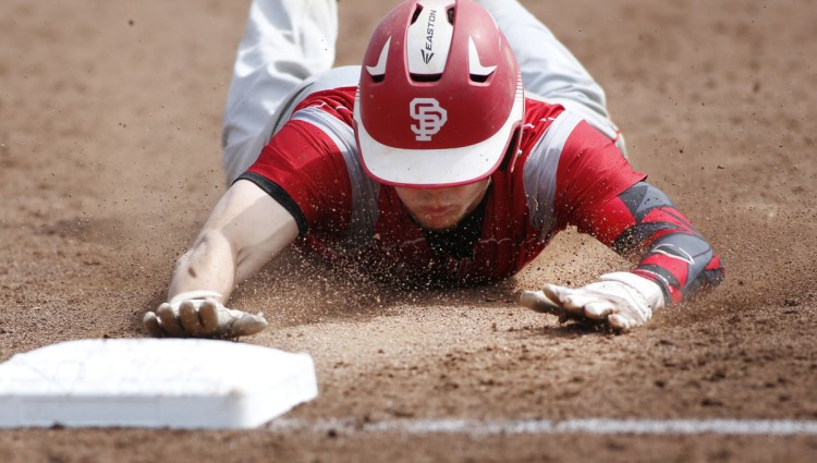 Riley Hasson of South Portland slides safely into third base during Saturday's game against Portland at Hadlock Field. The Red Riots allowed a run for the first time in five game but improved to 10-2.