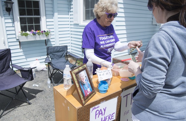 June Conley makes a sale Saturday at her house on Malbons Mills Road in Skowhegan during the area's 10 Mile Yard Sale. 