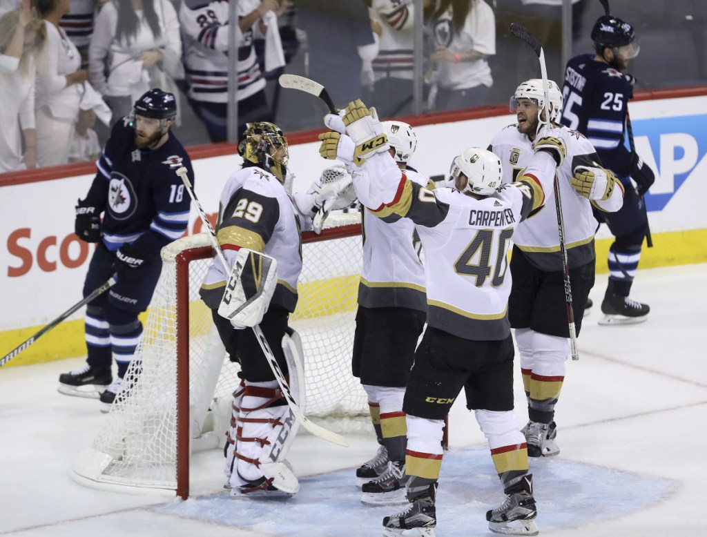 Vegas players congratulate goaltender Marc-Andre Fleury after the Golden Knights defeated the Winnipeg Jets 2-1 in Game 5 of the Western Conference finals Sunday to advance to the Stanley Cup finals.