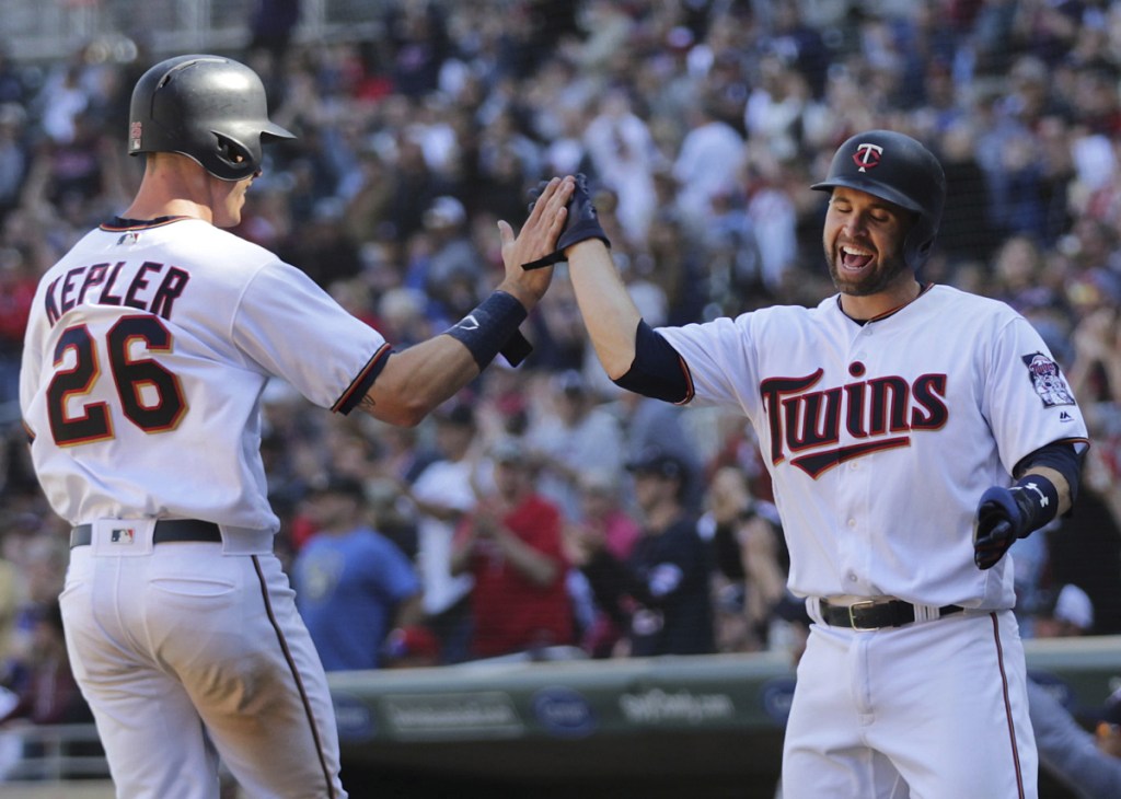 Max Kepler, left, and Brian Dozier celebrate after scoring on Logan Morrison's two-run double Sunday, helping the Twins beat the Brewers, 3-1.