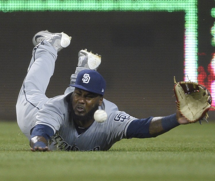 Right fielder Franmil Reyes of the San Diego Padres dives for a ball hit by Michael Taylor of Washington that went for a triple in the sixth inning Monday night. The Nationals came away with a 10-2 victory.