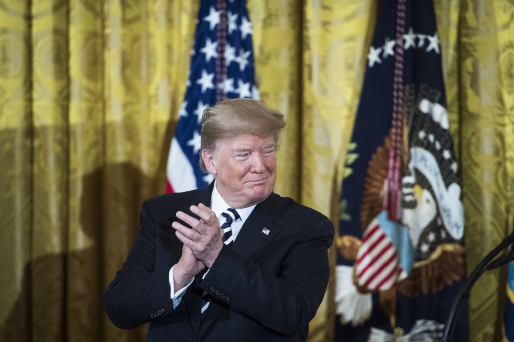 President Donald Trump claps after presenting the Medal of Honor to retired Navy SEAL Britt Slabinski in the East Room of the White House on Thursday. MUST CREDIT: Washington Post photo by Jabin Botsford
