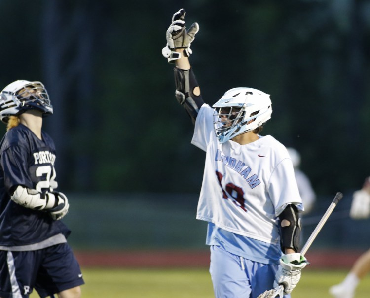 Travis Brown of Windham celebrates his goal late in the game Friday night as Ben Thompson of Portland reacts. Windham went on to an 8-7 victory that ended the Bulldogs' chances for a perfect regular season.