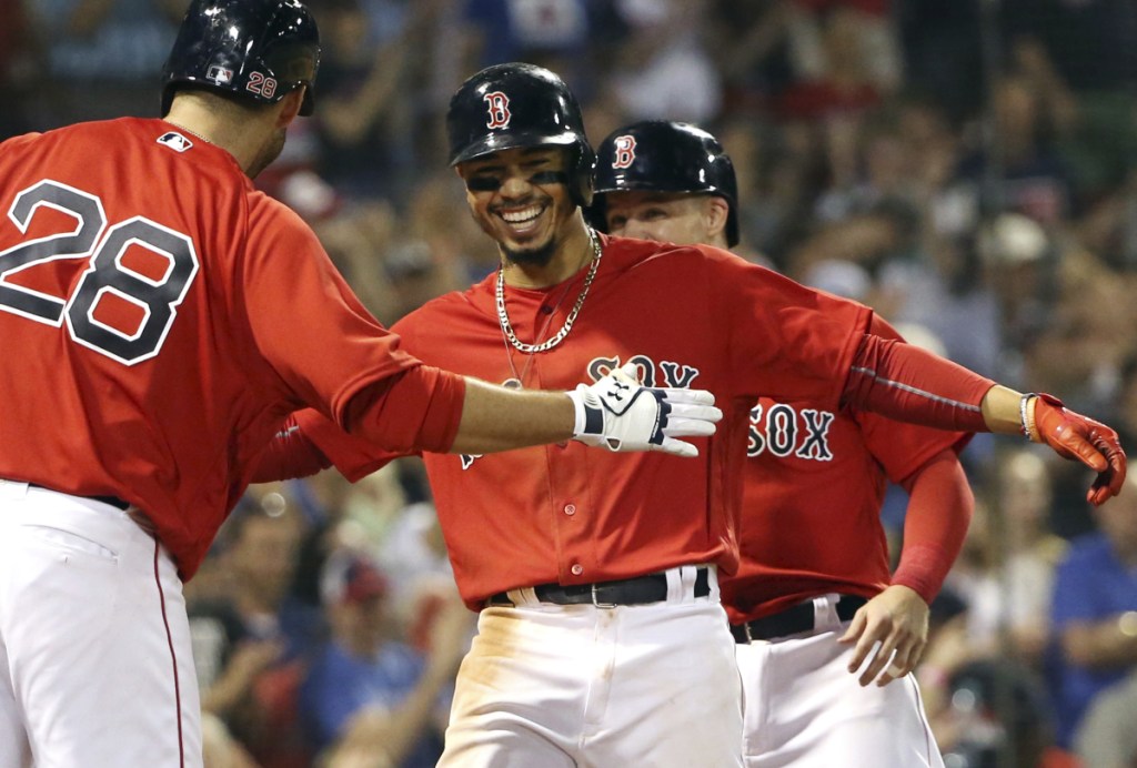 Mookie Betts celebrates with J.D. Martinez after hitting a two-run home run in the seventh inning Friday night at Fenway Park.