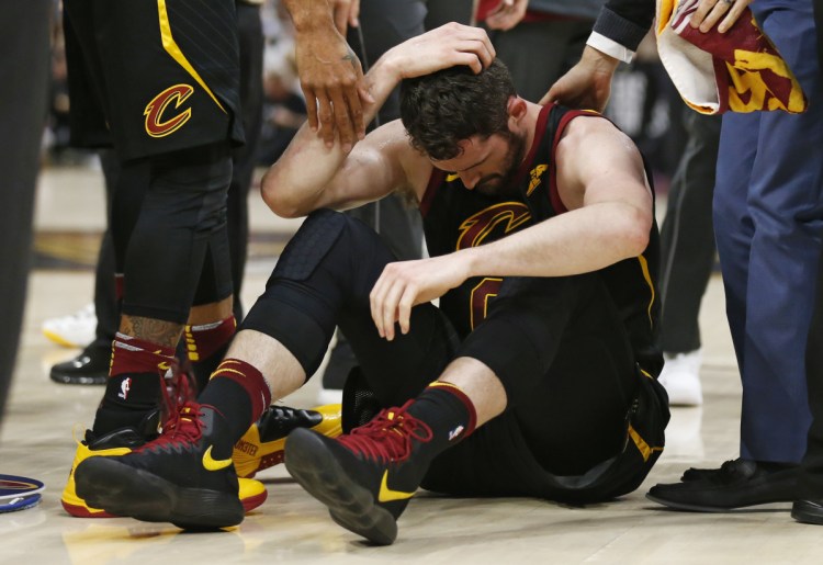 Cleveland's Kevin Love sits on the court while holding his head during the first half of Game 6 after colliding with Jayson Tatum the Boston Celtics. Love will not bew available for Game 7.