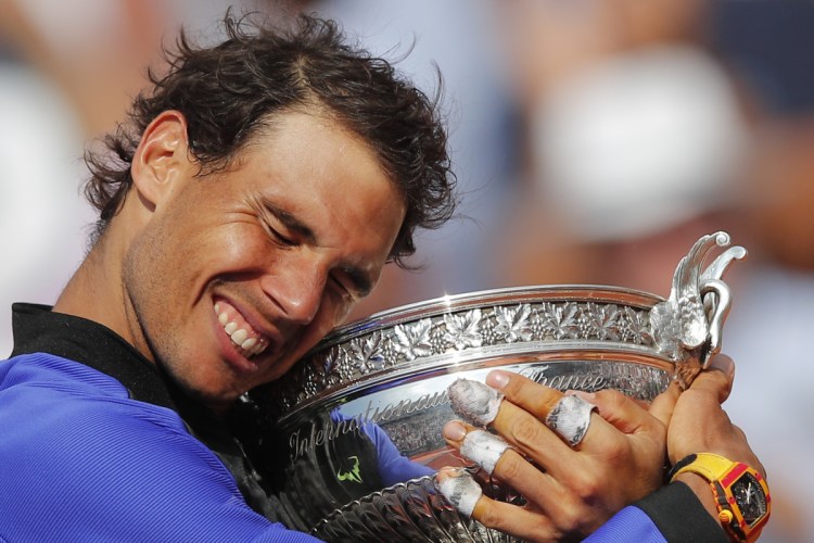 Spain's Rafael Nadal holds the trophy as he celebrates winning his 10th French Open title on June 11, 2017, after defeating Switzerland's Stan Wawrinka in three sets, 6-2, 6-3, 6-1.