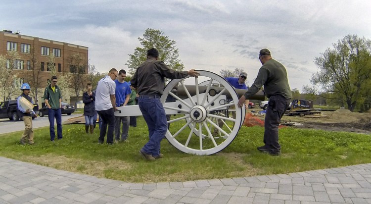Togus staffers, volunteers and Lewiston Regional Technical Center students and staff roll the new carriage the students built for a Civil War-era 12-pound Napoleon cannon on Thursday at VA Maine Healthcare Systems-Togus campus. 