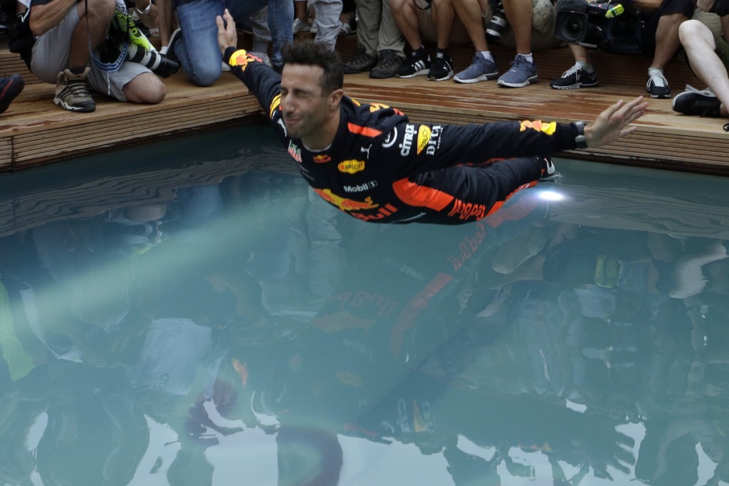 Red Bull driver Daniel Ricciardo, center, dives into a pool after winning the Formula One race Sunday at the Monaco racetrack in Monaco.