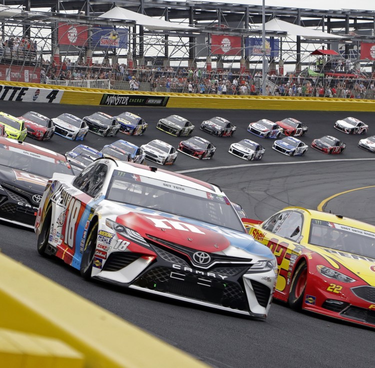 Kyle Busch, front left, leads the field Sunday night at the start of the Coca-Cola 600 at Charlotte Motor Speedway. Busch led most of the race and was in front at the end of all four stages.