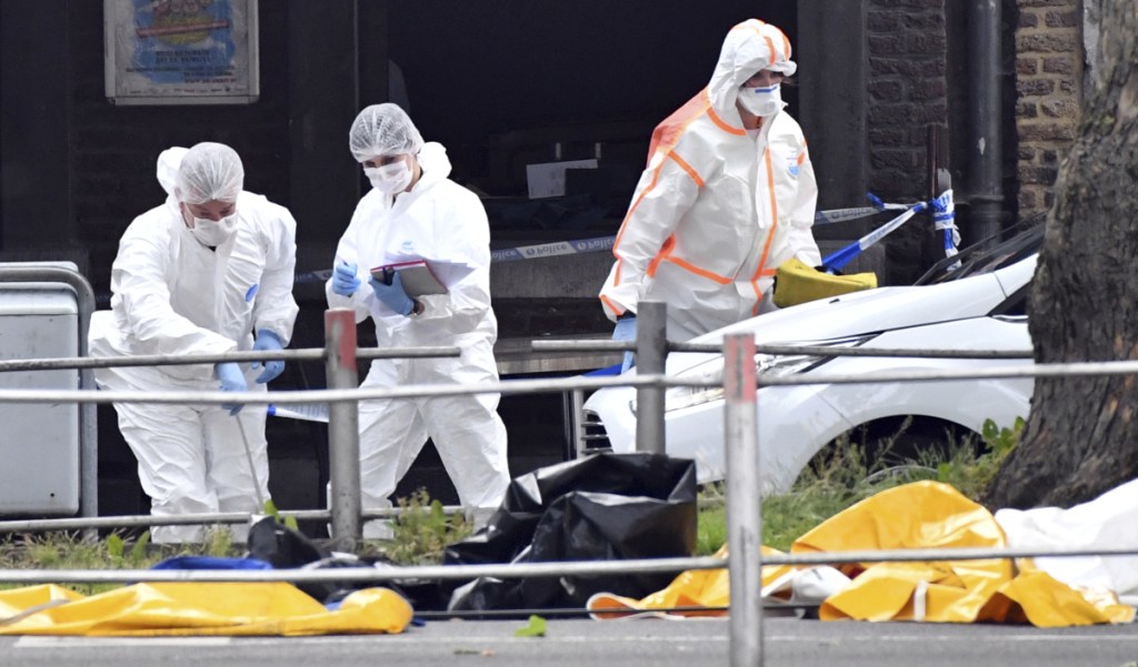 Forensic police investigate at the scene of a shooting in Liege, Belgium on Tuesday. A gunman killed three people, including two police officers a city official said. Police later killed the attacker.
