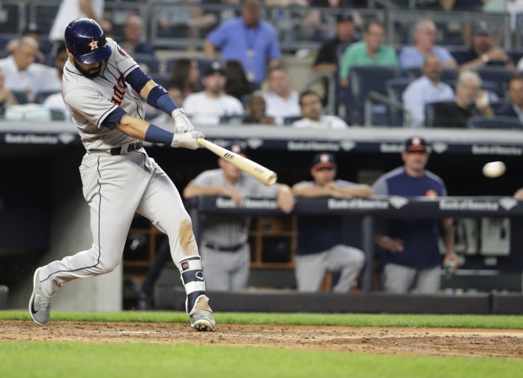 Houston's Marwin Gonzalez follows through on a two-run double in the fourth inning Tuesday night at New York. The Yankees won in 10 innings, 6-5.