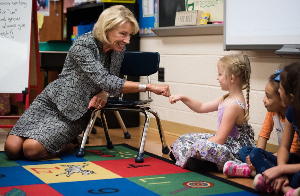 Education Secretary Betsy DeVos greets first-grader Annabelle Devouin with a fist bump during a visit Thursday to Frank Hebron-Harman Elementary School in Hanover, Md.
