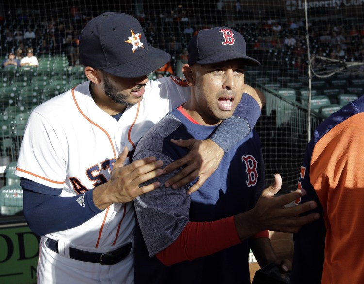 Boston Red Sox manager and former Houston Astros bench coach Alex Cora, right, is hugged by Astros shortstop Carlos Correa after Cora received his 2017 World Series Championship ring before Thursday's game in Houston.