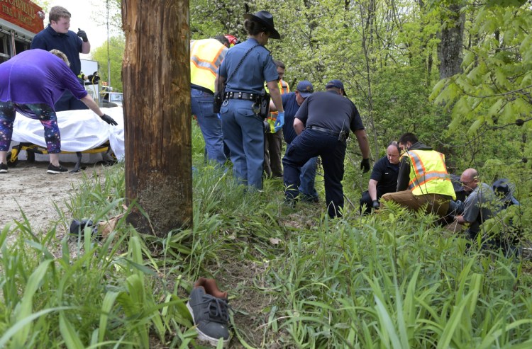 Firefighters and police carry the victim of a dirt bike accident Sunday morning on Oak Hill Road in Litchfield to an ambulance. Derek Parker, 35, died later of injuries he suffered in the morning accident, according to state police.