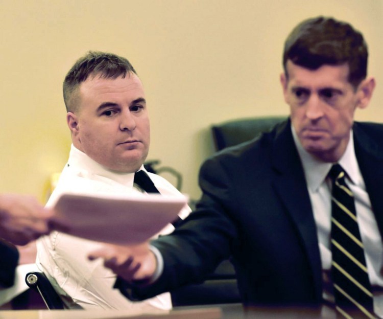 Defendant Jeremy Clement, left, watches as his attorney, Walter McKee, receives a court document Monday during the first day of his jury trial on charges of attempted murder in Kennebec County Superior Court in Augusta.