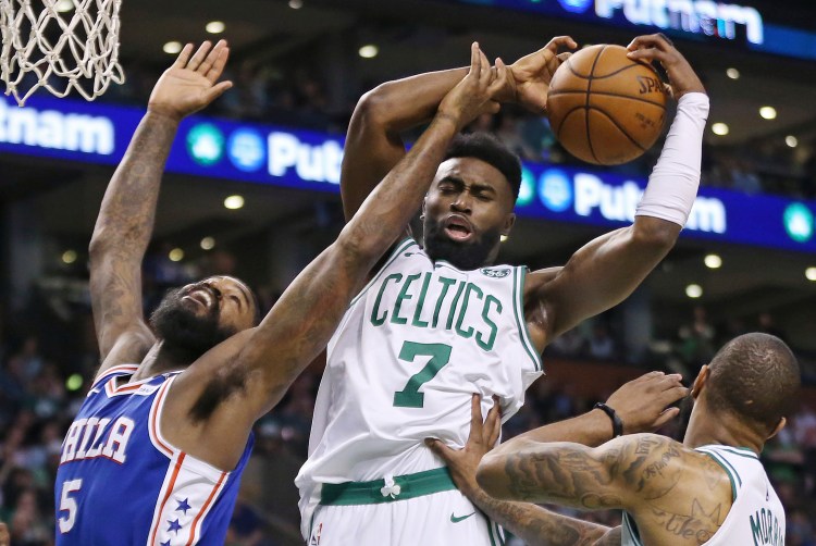 Boston Celtics guard Jaylen Brown pulls down a rebound over Philadelphia 76ers center Amir Johnson in the first quarter of Thursday night's game in Boston.