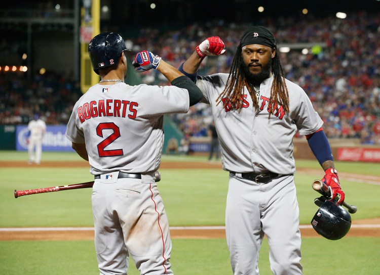 Boston Red Sox's Xander Bogaerts congratulates Hanley Ramirez, right, after Ramirez drove in the winning run against the Texas Rangers during the ninth inning Saturday in Arlington, Texas. 