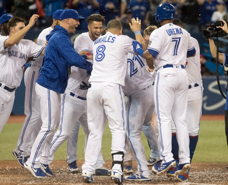 Toronto Blue Jays' Luke Maile is mobbed by teammates after he hit a walkoff home run in the twelfth inning of a baseball game against theBoston Red Sox in Toronto on Friday.