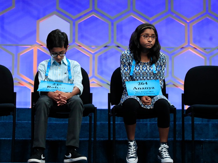 Rohan Rajeev, 14, left, returns to his seat after misspelling the word "marram," a Scandinavian-derived word for beach grass, while Ananya Vinay, waits for her turn during the 2017 Scripps National Spelling Bee. Vinay, won by spelling "marocain," a French word for dress fabric made of ribbed crepe. 