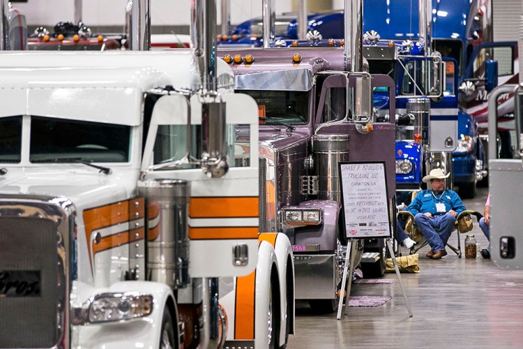 A truck owner sits by his custom rig among entrants in the "Pride and Polish" competition during the 16th annual Great American Trucking Show in Dallas in 2014. 